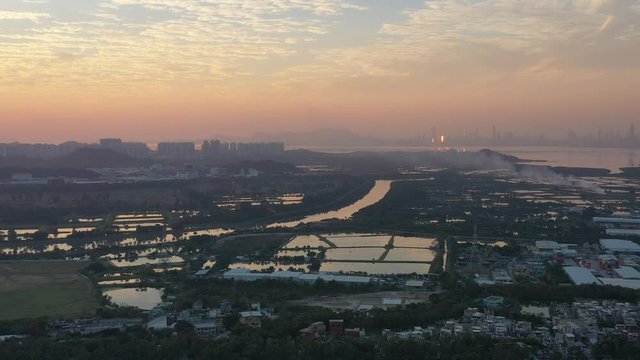 Aerial View of rural green fields in Hong Kong border and skylines in Shenzhen, China