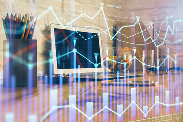 Double exposure of graph and financial info and work space with computer background. Concept of international online trading.
