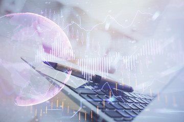 Stock market graph on background with desk and personal computer. Double exposure. Concept of financial analysis.
