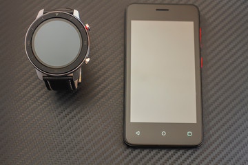 high-tech smart watch with a black silver strap on a carbon background