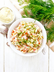 Salad of surimi and eggs with mayonnaise on light board top