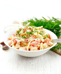 Salad of surimi and eggs with mayonnaise on wooden table