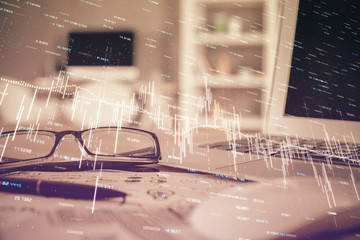 Financial chart hologram with glasses on the table background. Concept of business. Double exposure.