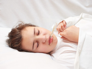 Obraz na płótnie Canvas sick girl lying in white bed with a thermometer in mouth. coronavirus
