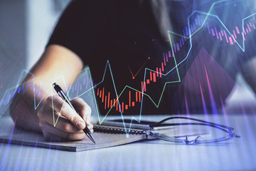 Multi exposure of woman's hands making notes with forex graph hologram. Concept of technical...