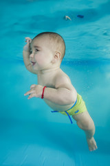 Fototapeta na wymiar boy learns to dive underwater in a swimming pool