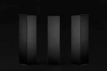 Collection of rectangle tall black paper boxes  - side view, front view on dark black background,...