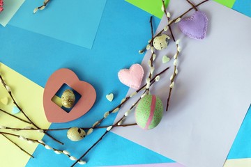 Easter decoration for the holiday, a wreath of eggs, hearts, pussy-willow branches on a bright background, top view