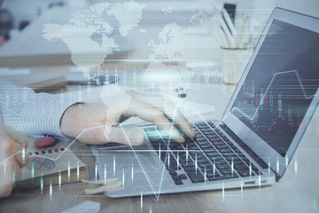 Double exposure of stock market graph with man working on laptop on background. Concept of financial analysis.