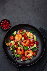 grilled shrimps and vegetable  salad on black plate