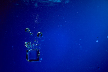 Ice cubes falling into the water