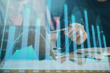 Forex graph with businessman typing on computer in office on background. Concept of analysis....