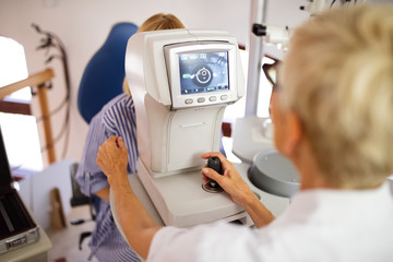 Optometrist examining patient in modern ophthalmology clinic