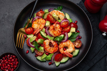 grilled shrimps and vegetable  salad on black plate
