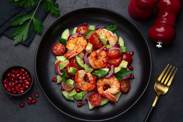 grilled shrimps and vegetable  salad on black plate