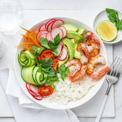 Avocado, prawn, cucumber, tomato, radish, carrot and rice salad bowl. Healthy food.