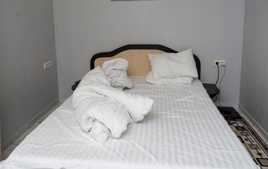 crumpled bed with white linens