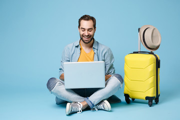 Funny traveler tourist man in yellow casual clothes isolated on blue background. Passenger...