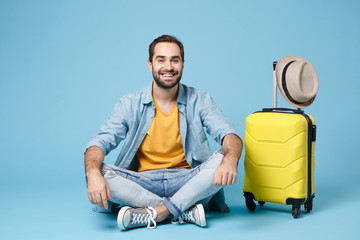 Smiling traveler tourist man in summer yellow casual clothes isolated on blue wall background. Male...