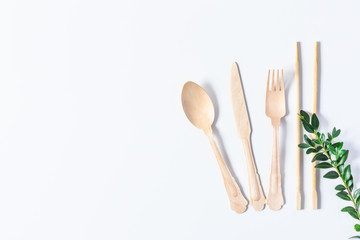 Eco friendly disposable tableware made of bamboo wood on white background top view.