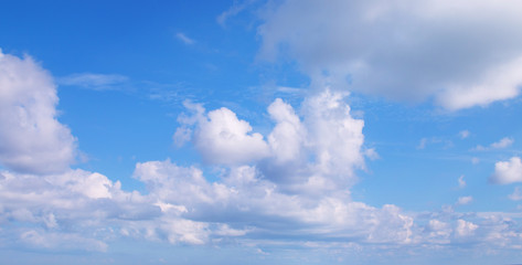 Naklejka na ściany i meble Blue sky covered with white clouds. Natural background. Panorama