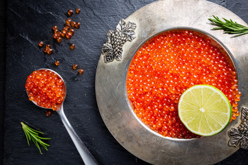 Delicious red caviar in vintage plate, top view, dark background