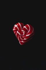 Single heart lollipop of valentines day on dark background