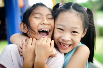 Happy children embracing each other and smiling at camera, motion blur.