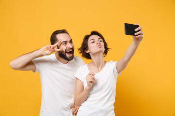 Funny couple friends bearded guy girl in white t-shirts isolated on yellow orange background....