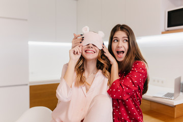 Funny brunette girl expressing positive emotions while joking with friend. Photo of stunning...