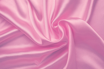 Pink silky background, abstract luxury textile texture. Purple smooth shiny fabric. Wavy satiny wallpaper. Romantic pink pattern on Valentine's Day.