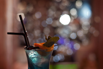 Blue cocktail on the bar counter. Drink with martini, gin, rum, tequila and fruit. Cocktail with...