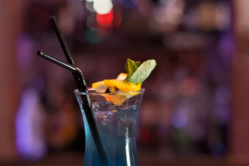 Blue cocktail on the bar counter. Drink with martini, gin, rum, tequila and fruit. Cocktail with...
