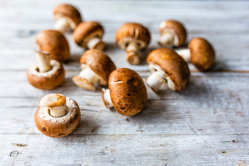 Fresh brown mushrooms in a wooden background.