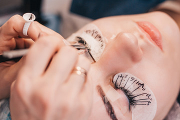the master works in turn with two eyes, putting the necessary eyelash in the right place - eyelash extension procedure