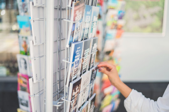 Choosing a postcard. A lot of diverse postcards