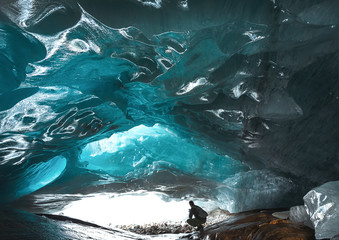 A man sits in a glacial cave inside the Alibek mountain glacier in Dombay, Caucasus