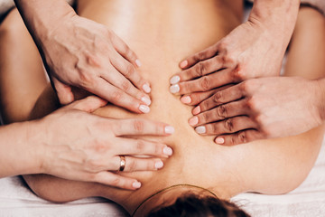 Four hands back massage - female hands on the patient's back