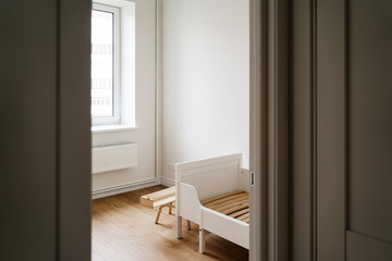 MInimal child room for toddler in white and wooden colors. Less waste lifestyle in parenting