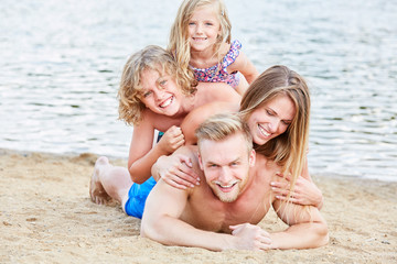 Fototapeta na wymiar Happy family with two kids at the beach