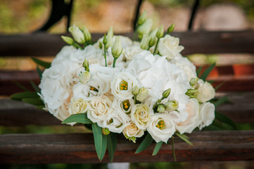 white flower bouquet lies on a bench