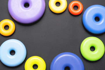 Colorful baby toys on black flat lay background with copy space.