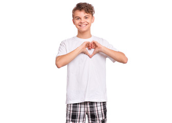 Happy teen boy making heart, isolated on white background. Smiling teenager showing heart symbol and shape with hands. Symbol of love, family, hope. Friendship and love concept. Valentines day.