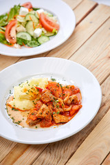 chicken with mashed potatoes and salad on the wooden background