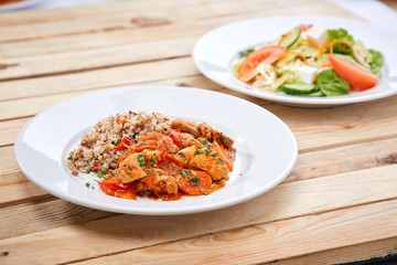meat with buckwheat and salad on the wooden background