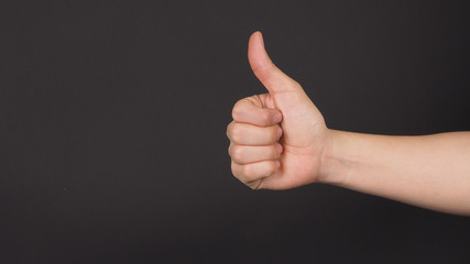 The thumbs up or like hand sign on black background.