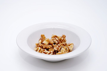 white bowl with peeled walnuts
