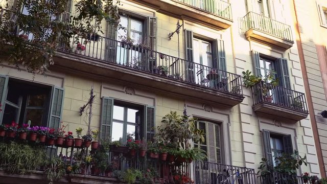 Facade of Barcelona old house with balconies with plants. Urban jungles. Ecological living