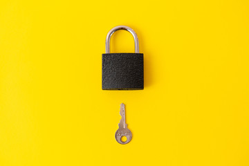 Lock and key on yellow background, top view. Pop art