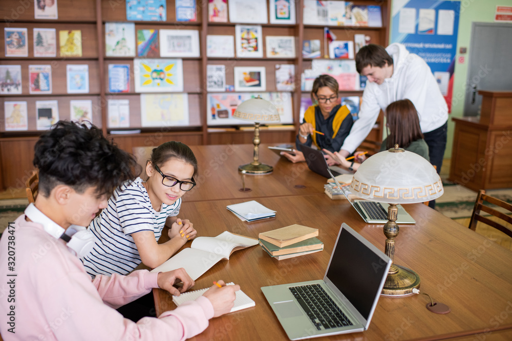 Aufkleber two small groups of contemporary college students sitting by desks and discussing their plans or poi